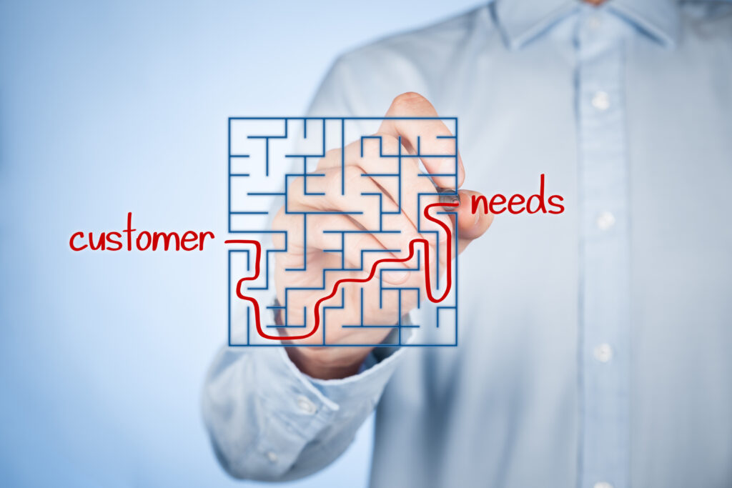 Man connecting the words "customer" and "needs" in a puzzle