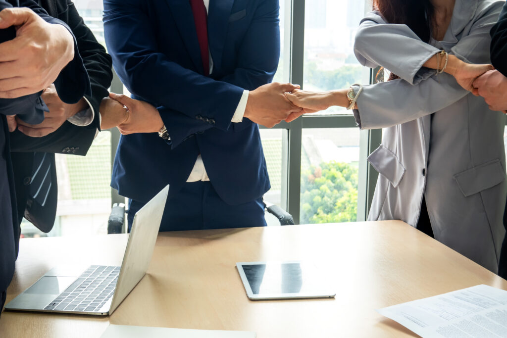 Business professionals holding each others hand's to each other showing business partnership.